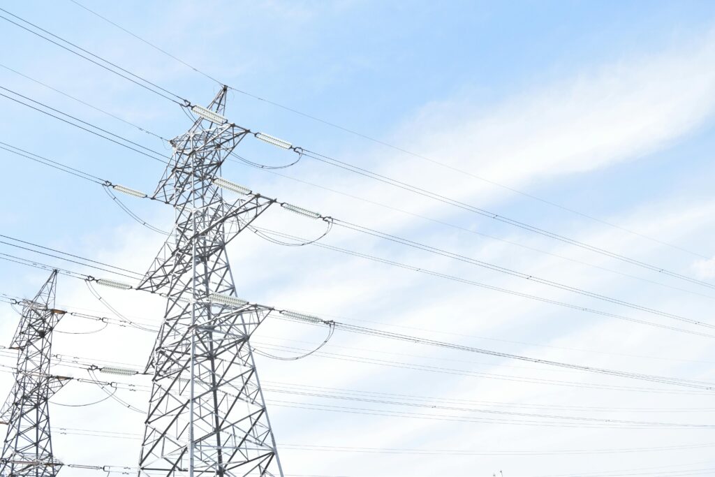 Steel transmission towers against blue sky, highlighting energy and electricity infrastructure.